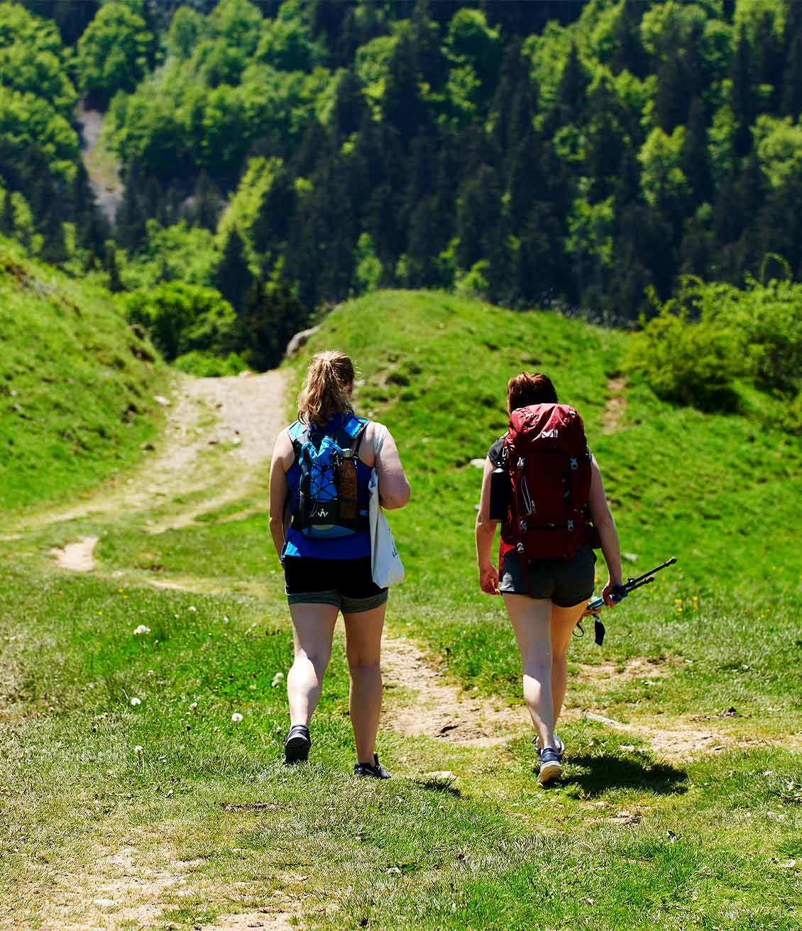 2 jeunes femmes qui partent en randonnée, sacs sur le doc et infusions froides dans les sacs